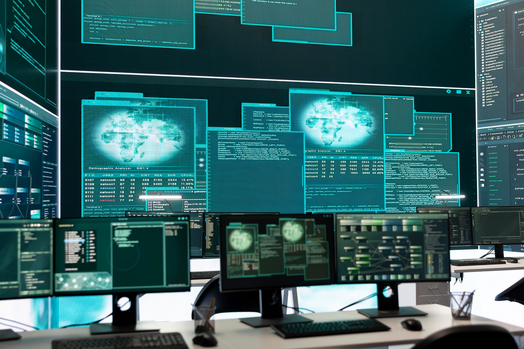 Multiple computer monitors displaying various screens and data on a desk setup.