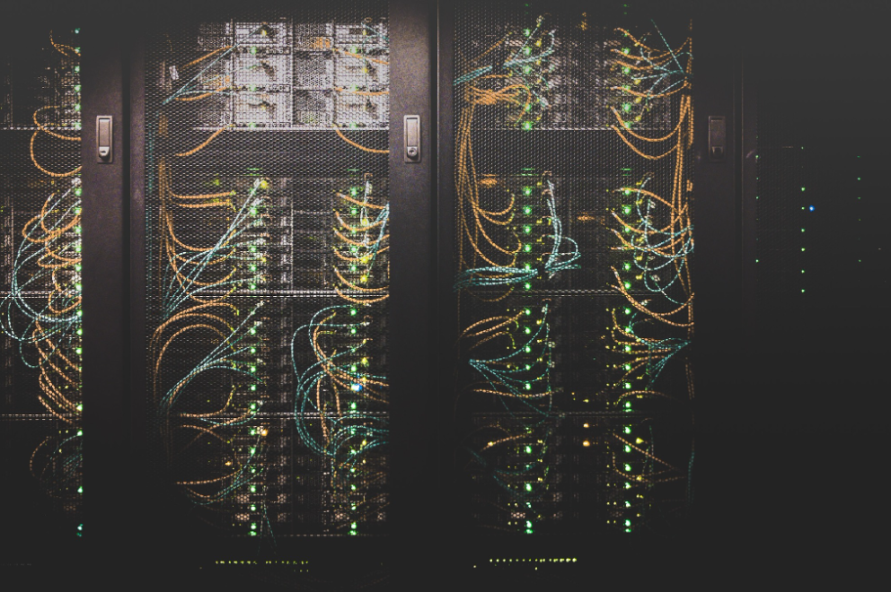 Data center server racks with organized orange and green fiber optic cables showing 100G QSFP28 network infrastructure and high-density port connections