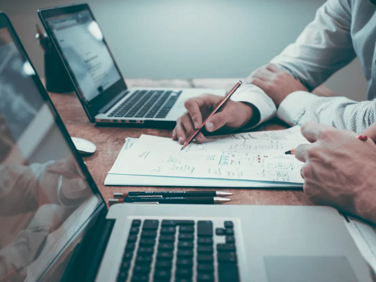 Network engineers collaborating and analyzing latency data and performance metrics for fiber optic network optimization