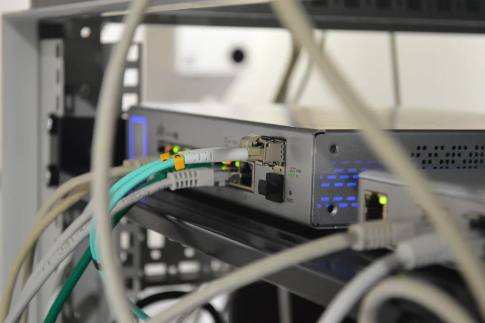 Network switch with fiber optic cables and transceivers connected showing proper cable installation and verification setup